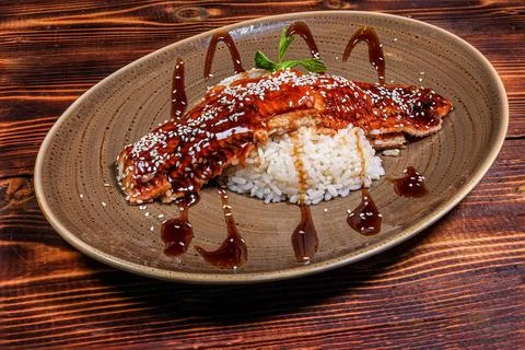 A delectable serving of teriyaki eel atop a bed of fluffy rice, sprinkled wit Foto stock
