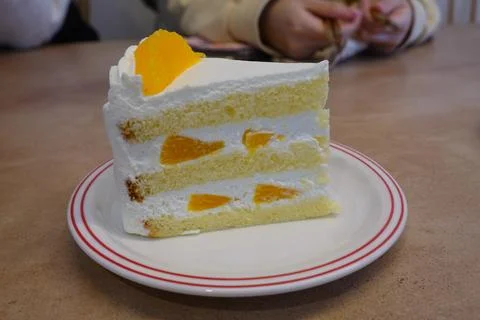 A delectable slice of cake with rich layers of cream and frosting, topped w.. Stock Photos