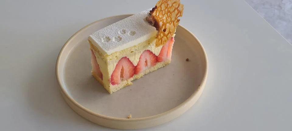 A delectable slice of cake with rich layers of cream and frosting, topped w.. Stock Photos