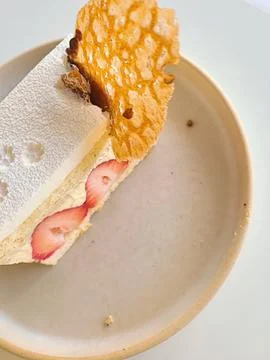 A delectable slice of cake with rich layers of cream and frosting, topped w.. Stock Photos