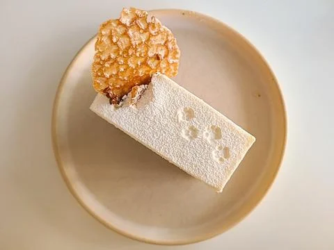 A delectable slice of cake with rich layers of cream and frosting, topped w.. Stock Photos