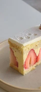 A delectable slice of cake with rich layers of cream and frosting, topped w.. Stock Photos