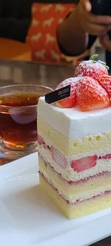 A delectable slice of cake with rich layers of cream and frosting, topped w.. Stock Photos