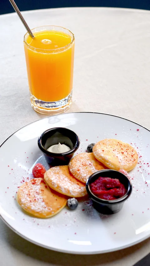 Delectable small pancakes arranged with fresh forest berries, homemade jam Video stock 312397577