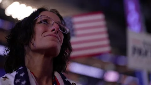 A delegate with an American flag scarf looks up at the stage, RNC Dallas 2026 Stock Footage 345271624