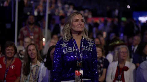 A delegate in a sequined 'USA' jacket stands in the crowd, RNC Dallas 2026 Stock-Footage 345274932