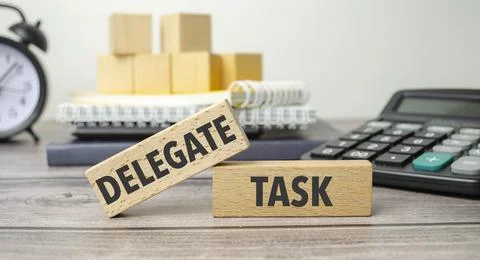 Delegate task is shown on a conceptual photo using wooden blocks Stock Photos