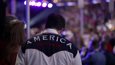 A delegate in a western-style 'America' jacket stands in the crowd Stock Footage 345274184
