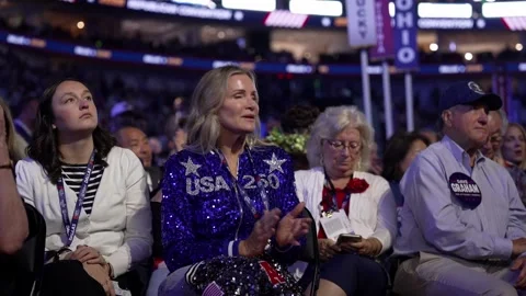 Delegates, one in a sequined 'USA 250' jacket, listen to the speech Stock-Footage 345274877