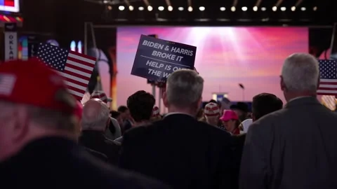 Delegates stand beneath a 'Biden and Harris Broke It' sign, RNC Dallas 2026 Stock Footage 345271524