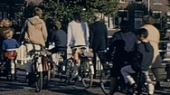 Delft, Holland - 1965: People Cross A Bridge With Their Bikes Stock Footage
