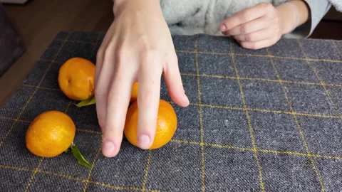 Deliberate placement of mandarins on fabric surface with greenery Stock Footage 323358729