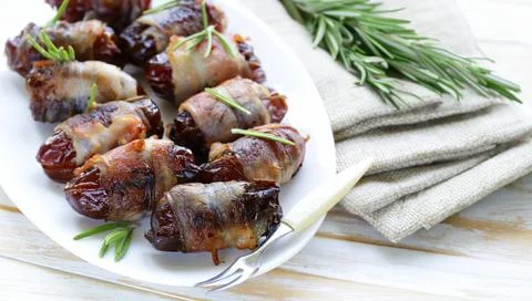 Delicacy appetizer fried dates with bacon and rosemary Stock Photos