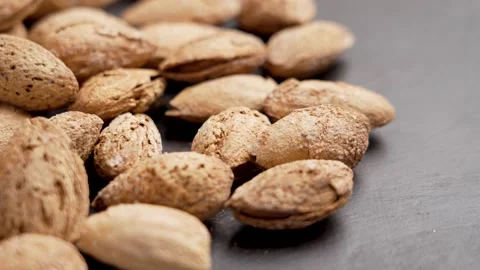 Delicacy roasted almond nuts with nutshell on a brown board Stock Footage 256708961