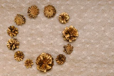 Delicate background of pine gilded cones, set in the form of a circular frame on Stock Photos