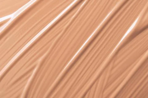 Delicate beige smeared texture of BB face cream, tonal foundation is smudged. 库存照片