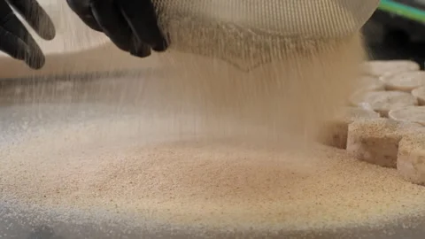 Delicate breadcrumbs fall through sieve creating soft layer for shaped patties Video stock 323705272