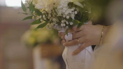 Delicate bride holding her white flower wedding bouquet at the church ceremony Video stock 105161933