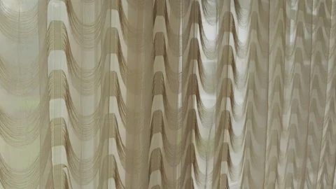 Delicate brown sheer string curtains with a wavy pattern gently moving Stock Footage 345671030