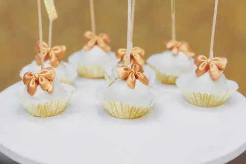 Delicate cake pops sit on a white plate Foto stock