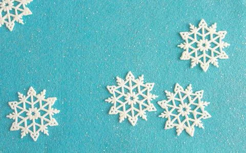 Delicate christmas composition, snowflakes on blue felt background, copy space Stock Photos