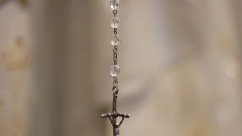 Delicate crucifix pendant hangs in focus, symbolizing faith and devotion. Stock-Footage 285435408