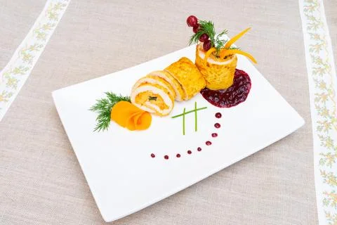 Delicate culinary presentation of rolled chicken with garnishes and sauces Stock Photos