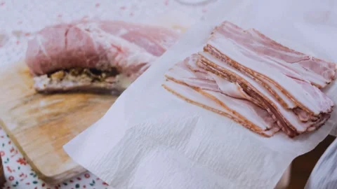 Delicate dynamic preparation: arranging bacon strips under stuffed pork Stock Footage 342184605