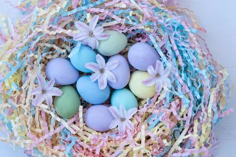 Delicate Easter picture. There are colorful quail eggs and pink flowers in the Stock Photos