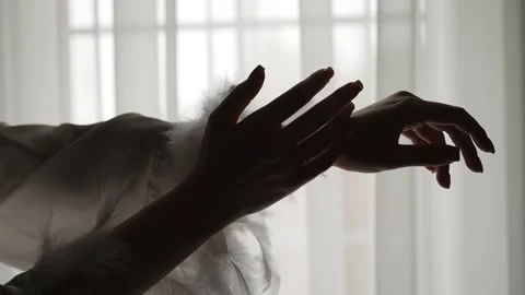Delicate female hands silhouetted Видео 332980432