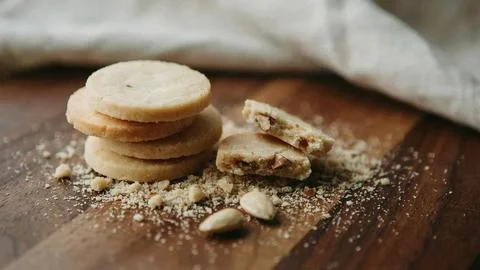 Delicate French macarons arranged on a rustic wooden surface dusted with Stock Photos