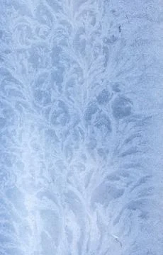 Delicate frost patterns forming on a cold window surface Stock Photos