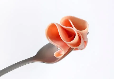 Delicate ham rose on a silver fork Stock Photos