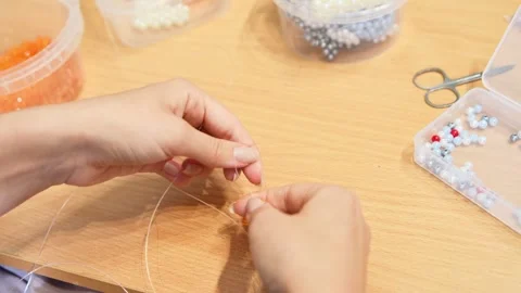 Delicate hand beading craft with transparent thread and colorful beads on w.. Vídeo Stock 339565780