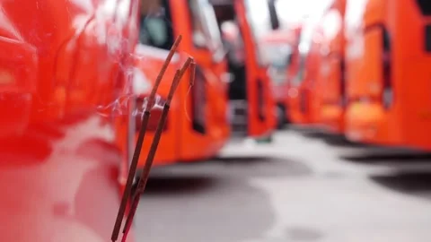 Delicate incense smoke flows upward from sticks near a red headlight 스톡 동영상 314888995