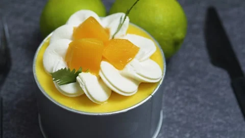 Delicate mango mousse cake Tin Can garnished with cream rosettes, fresh mango Stock Footage 313291471