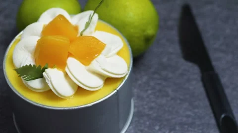 Delicate mango mousse cake Tin Can garnished with cream rosettes, diced mango, Stock Footage 313292829