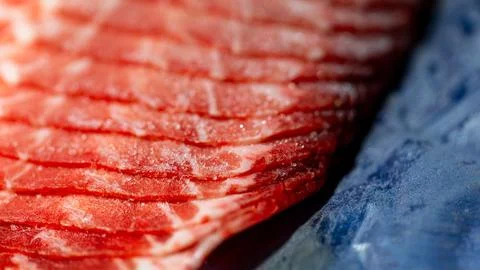 The delicate marbled texture of bright red frozen pork slices Stock Photos
