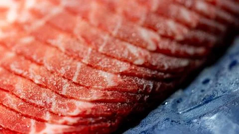 The delicate marbled texture of bright red frozen pork slices Stock Photos