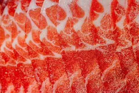 The delicate marbled texture of bright red frozen pork slices Stock Photos