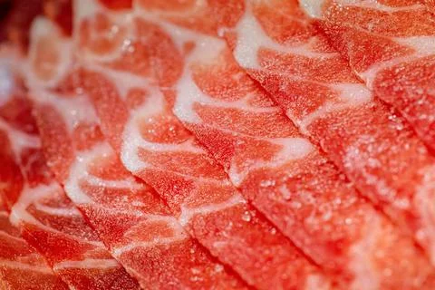The delicate marbled texture of bright red frozen pork slices Stock Photos