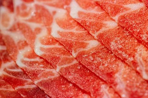 The delicate marbled texture of bright red frozen pork slices Stock Photos