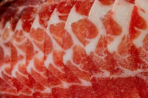 The delicate marbled texture of bright red frozen pork slices Stock Photos