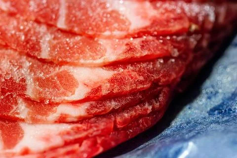 The delicate marbled texture of bright red frozen pork slices Stock Photos
