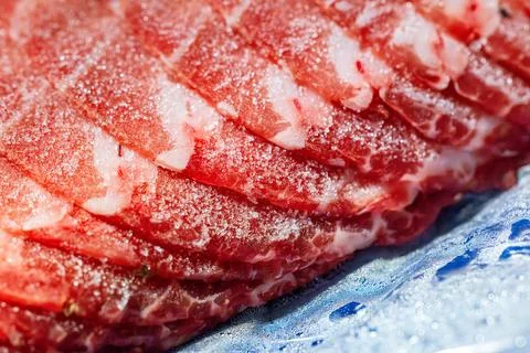 The delicate marbled texture of bright red frozen pork slices Stock Photos