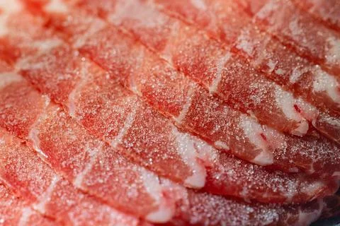 The delicate marbled texture of bright red frozen pork slices Stock Photos