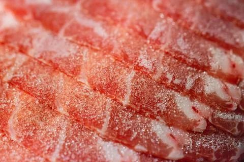 The delicate marbled texture of bright red frozen pork slices Stock Photos