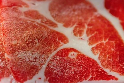 The delicate marbled texture of bright red frozen pork slices Stock Photos