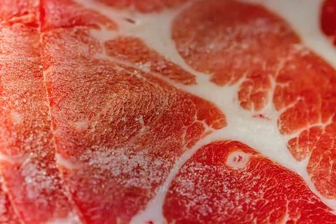 The delicate marbled texture of bright red frozen pork slices Stock Photos