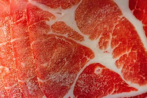 The delicate marbled texture of bright red frozen pork slices Stock Photos